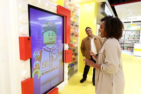 A woman in front of a facial recognition screen in the Lego Fifth Avenue store